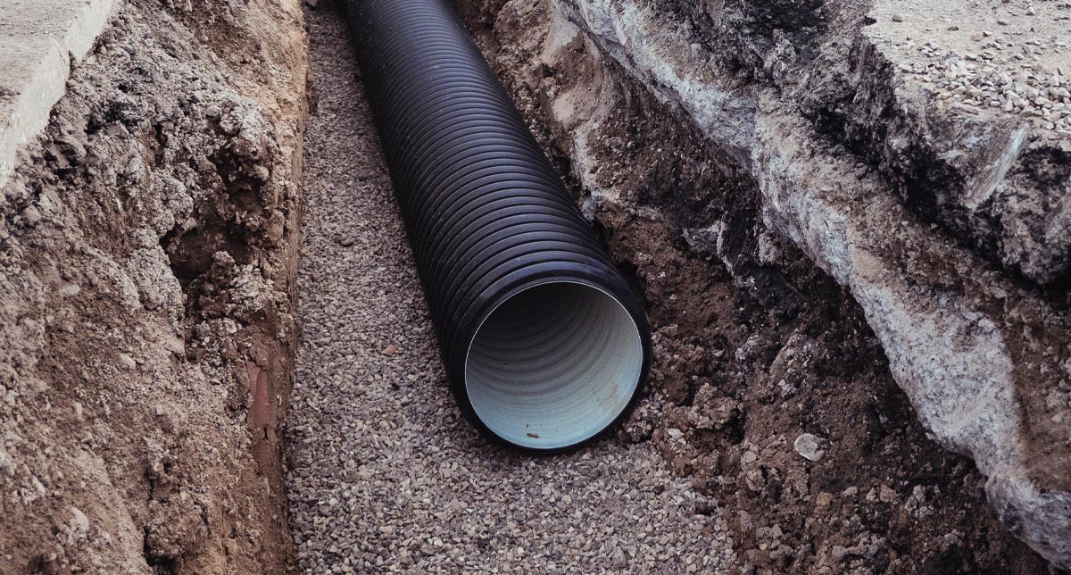 Large corrugated drainage pipe installed in a trench during construction.