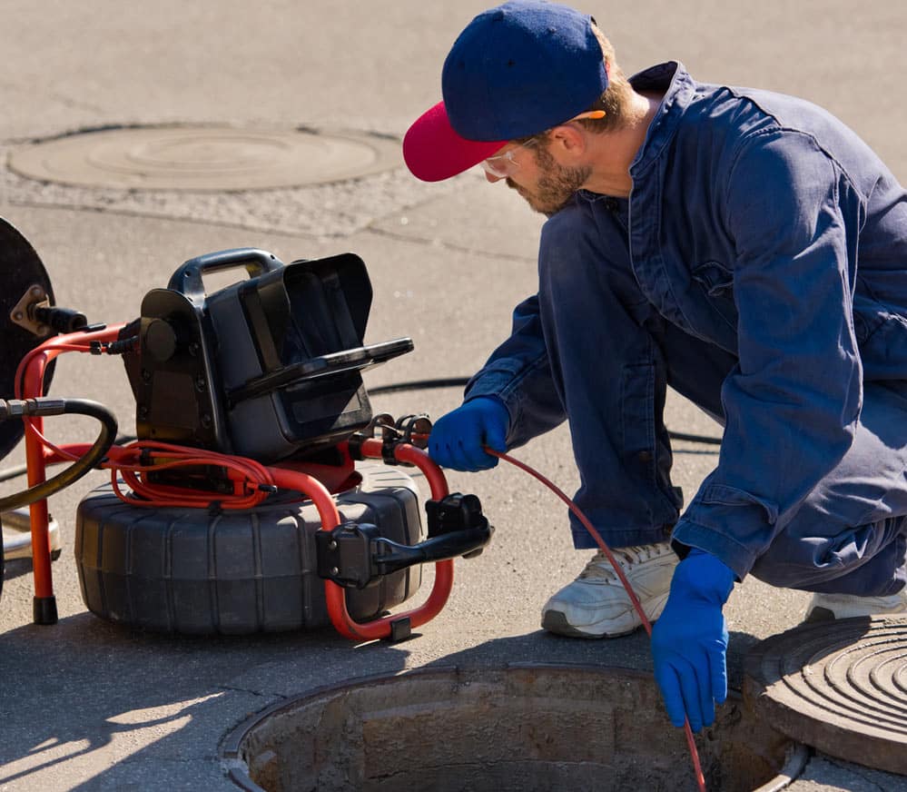 Plumber using sewer inspection camera to check pipes