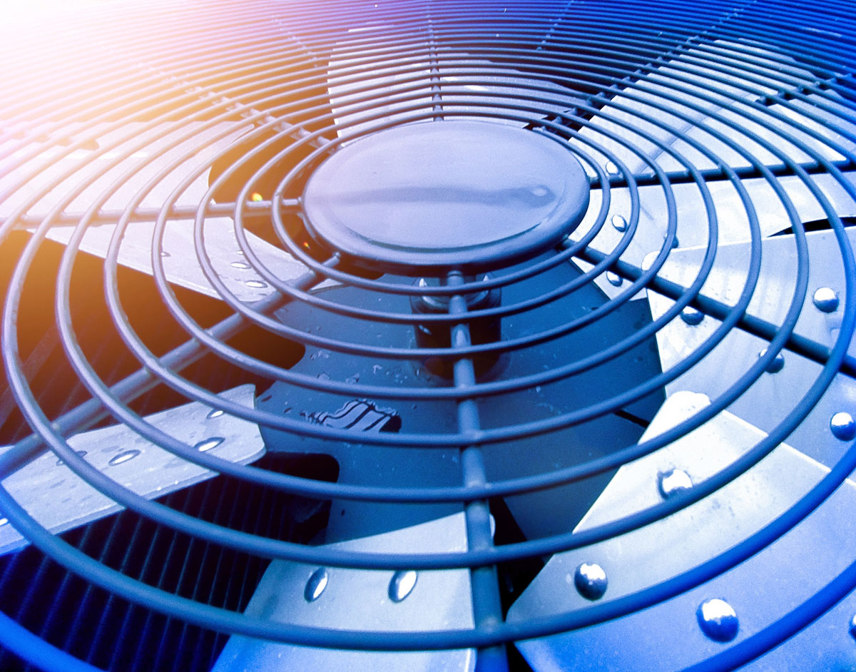 Close-up of an air conditioning unit fan, showing intricate metal blades and circular grill.