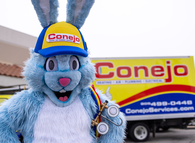 Conejo Services mascot, a blue bunny, wearing a Conejo hat and HVAC tools.