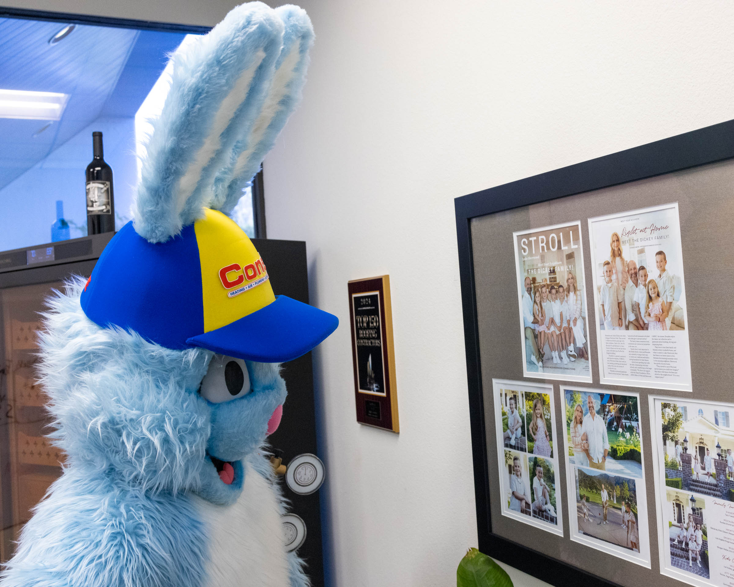 Conejo Services mascot, Gauge the Rabbit, looking at a feature article about Branden Dickey's family